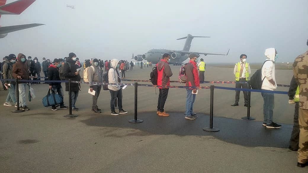 Passengers line up for verification and medical check up after embarkment from the two flights in New Delhi.