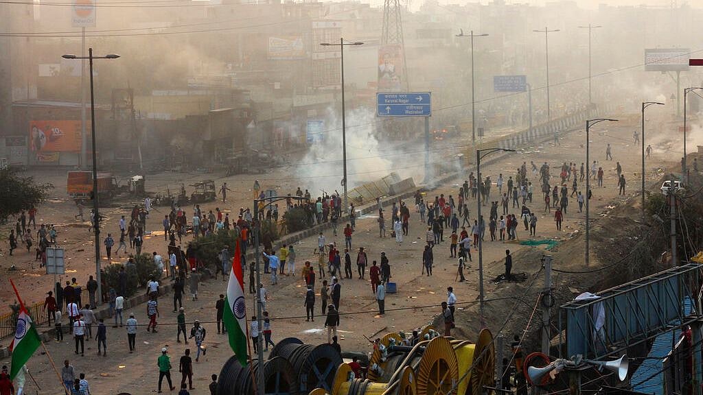 People stand on a street during clashes between hundreds of supporters and opponents of a new citizenship law in New Delhi, India, Monday, 24 February.