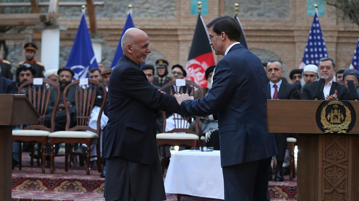 Afghan President Ashraf Ghani shakes hands with US Secretary of Defense Mark Esper after a joint news conference in presidential palace in Kabul on 29 February. 