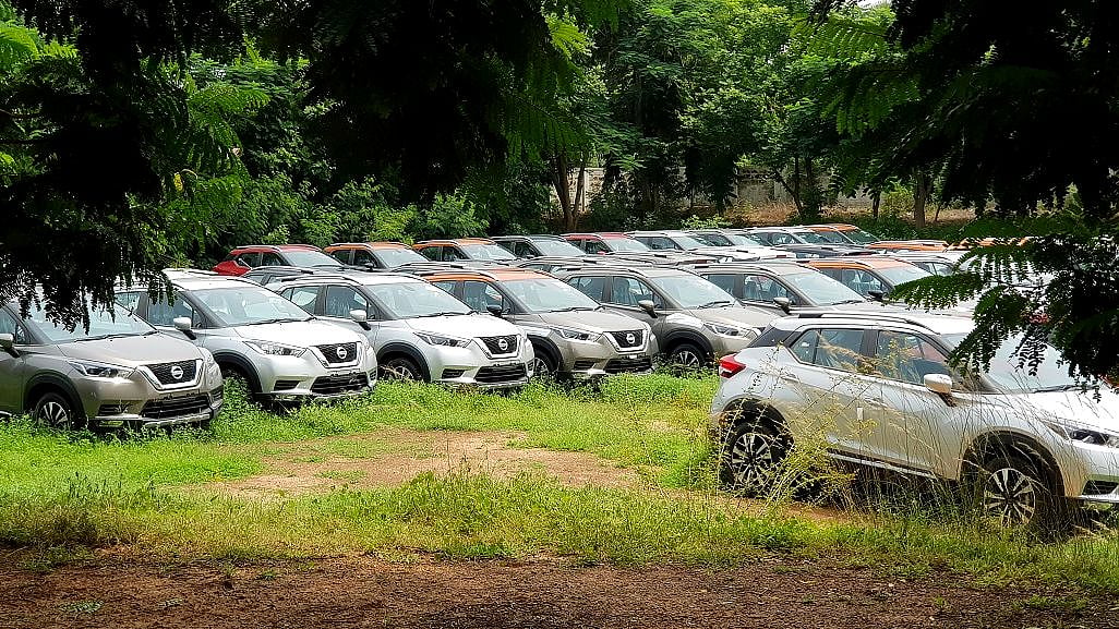 New cars lined up at a yard awaiting shipment.