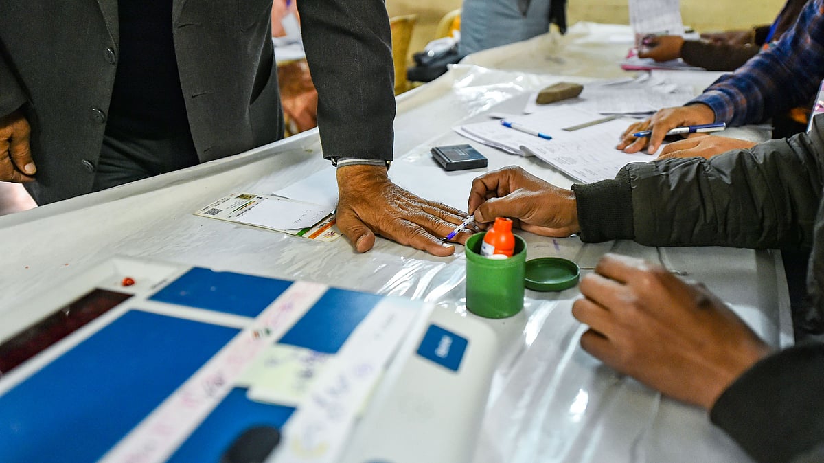 A polling official applies indelible ink on the finger of a voter during the Delhi Assembly elections at Old Rajinder Nagar polling station, in New Delhi, Saturday, Feb. 8, 2020.