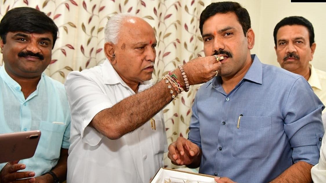 Karnataka Chief Minister BS Yediyurappa celebrates with his son BY Vijayendra. 