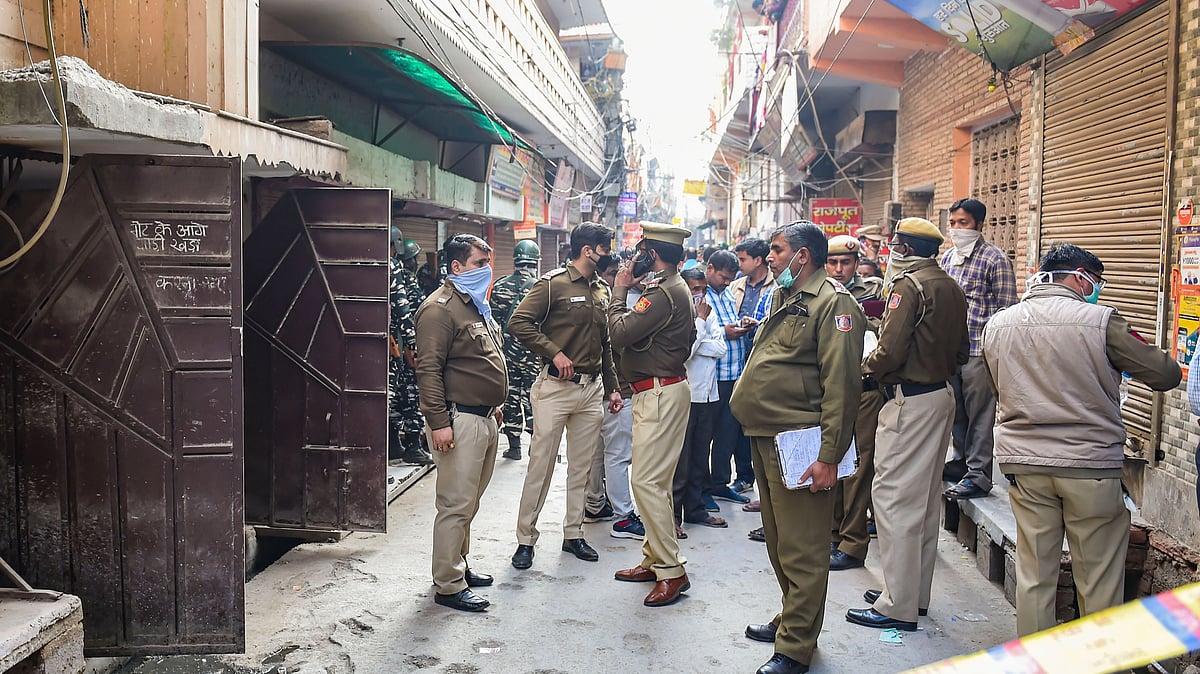 Police personnel stand outside a house where five members of a family were found dead at Bhajanpura area of New Delhi, Wednesday, 12 February. 