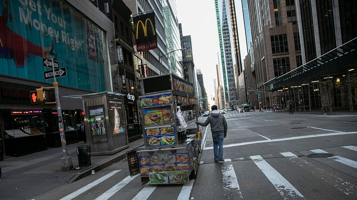 A food truck vendor pushes his cart down an empty street near Times Square in New York, on Sunday, 15 March 2020.
