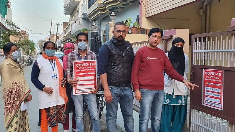 Health department workers putting a poster outside the home of a COVID-19 patient in Rajasthan’s Sri Ganganagar district.