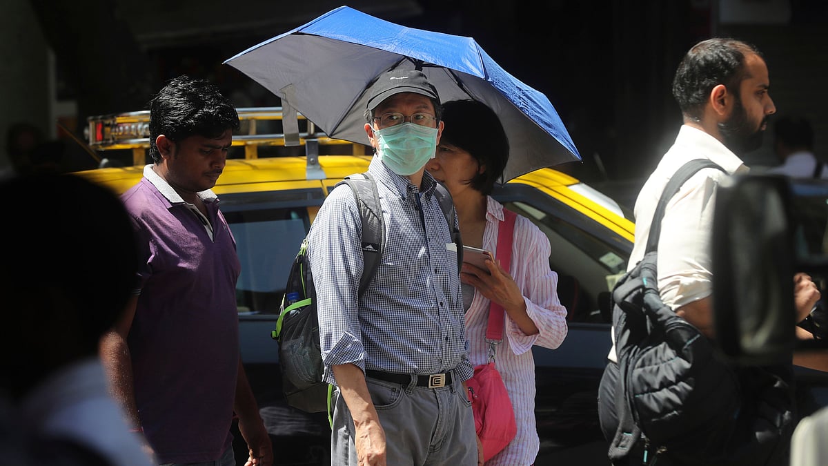 A tourist wearing mask walks through a street in Mumbai, India, Thursday.