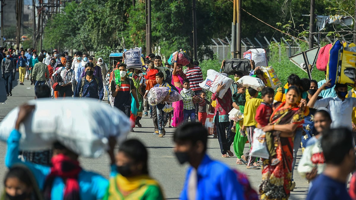 Migrant workers  amid a nationwide lockdown at Lal Quarter Bus Stand in New Delhi, Sunday.
