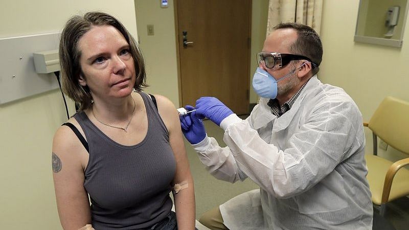 A pharmacist gives Jennifer Haller, left, the first shot in the first-stage safety study clinical trial of a potential vaccine for COVID-19.
