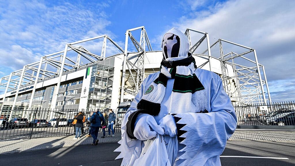 A Borussia fan dressed as ghost stands in front of the stadium prior the German Bundesliga soccer match between Borussia Moenchengladbach and 1 FC Cologne in Moenchengladbach, Germany, Wednesday, 11 March. It is the first Bundesliga match played behind closed doors without spectators due to the coronavirus outbreak. 