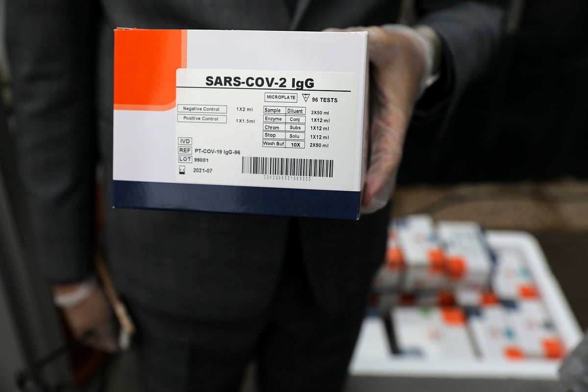 A medical firm staff holds a coronavirus testing kit.