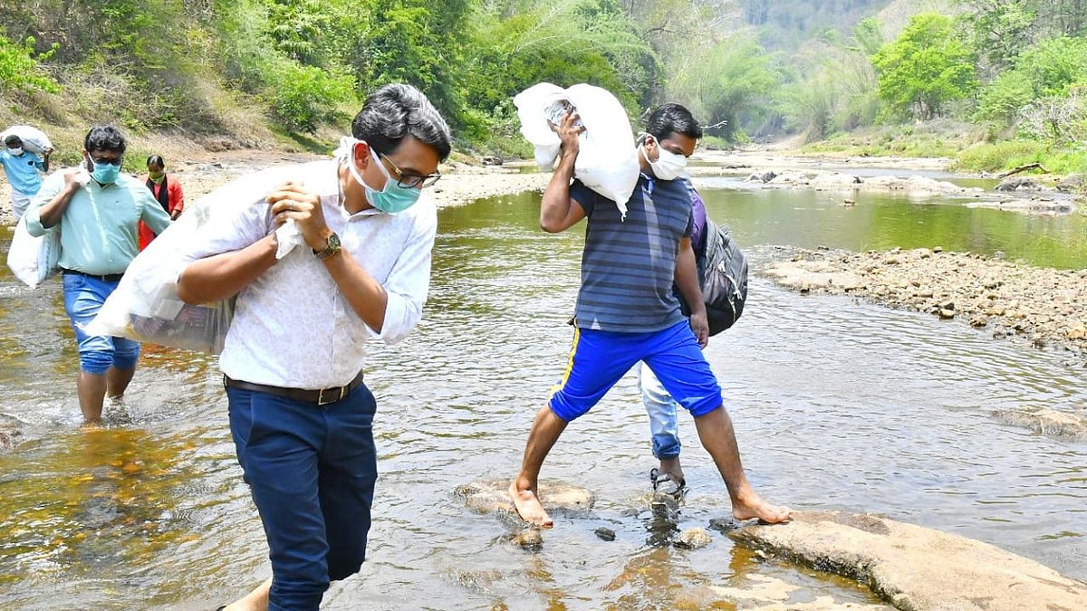 Pathanamthitta collector PB Nooh carries supplies to a hilly area where tribals reside.
