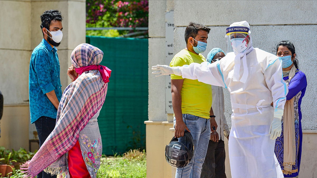 A medic in protective suit instructs people coming to a hospital for check-up. Image used for representational purpose only.&nbsp;