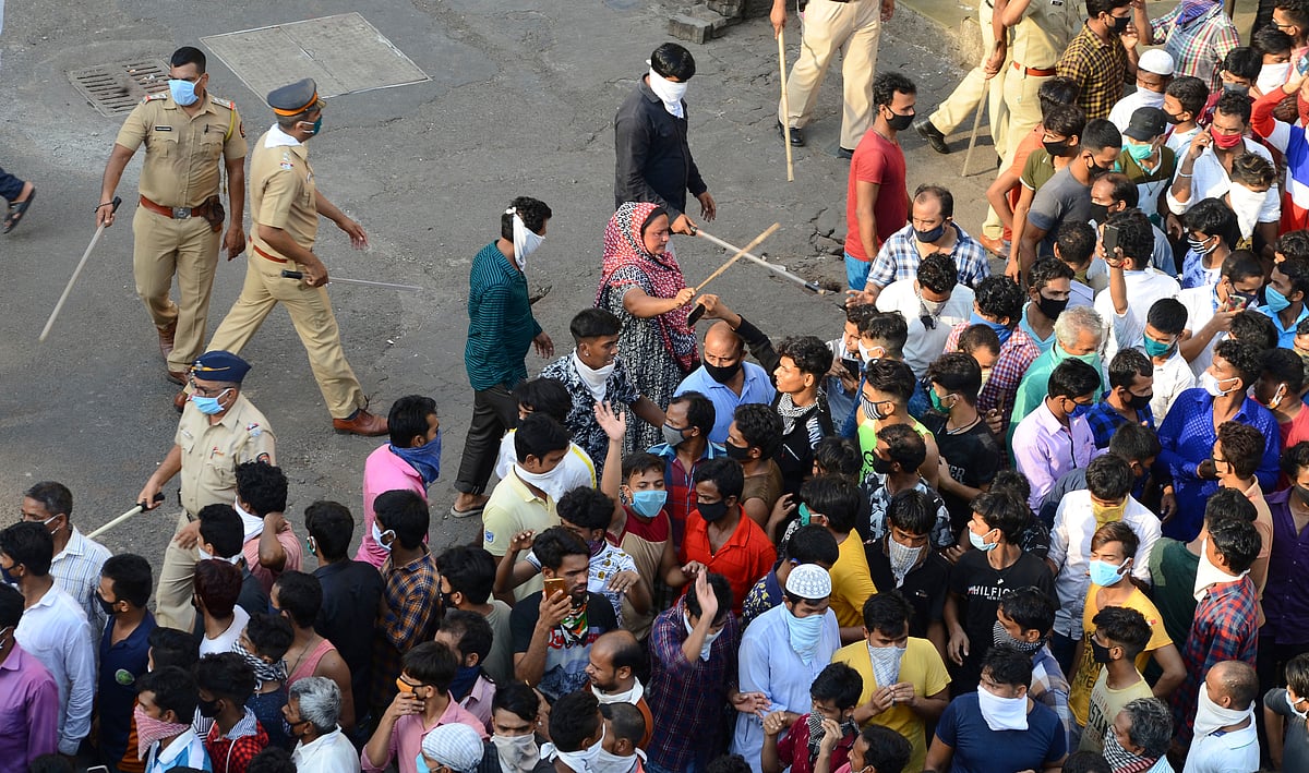 Police try to control migrant workers protesting against the the extension of the lockdown, at a slum in Mumbai, India.