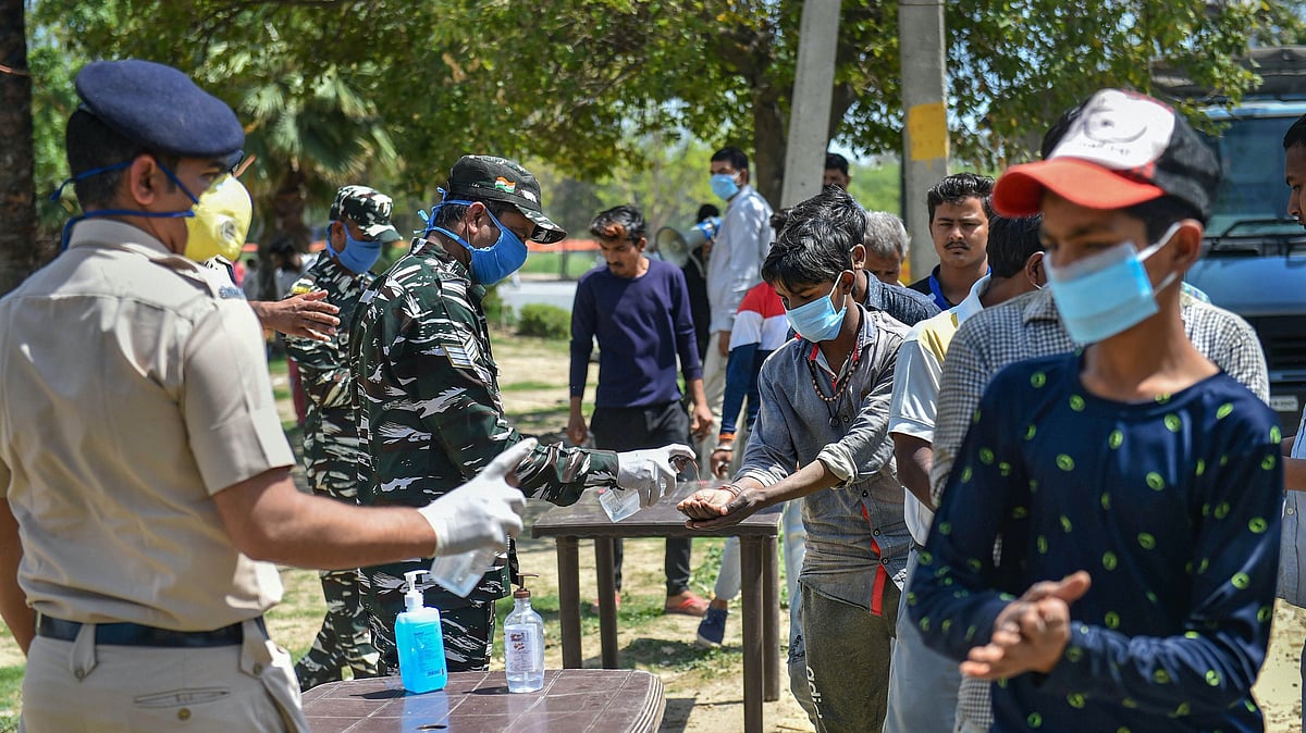 CRPF personnel pump hand sanitiser on the hands of people during a nationwide lockdown, imposed in the wake of coronavirus pandemic. Representational image. 
