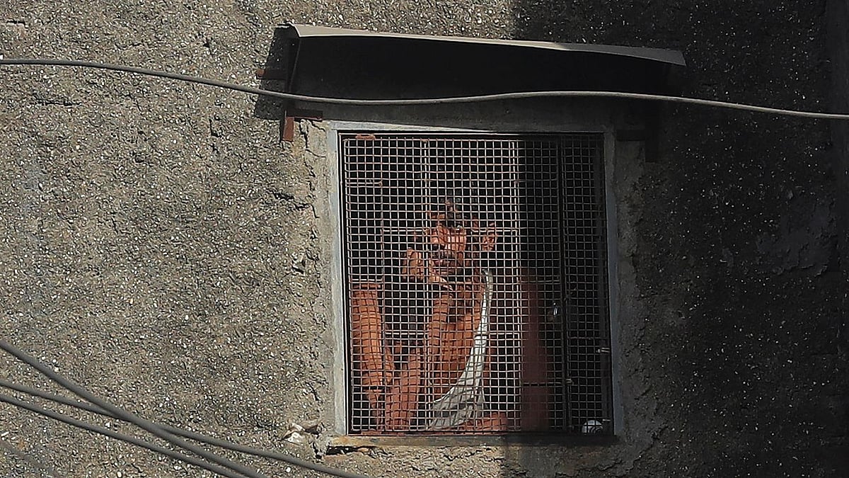 A migrant worker from another state looks through the window of his room in Dharavi, one of Asia’s largest slums, during lockdown to prevent the spread of the new coronavirus.
