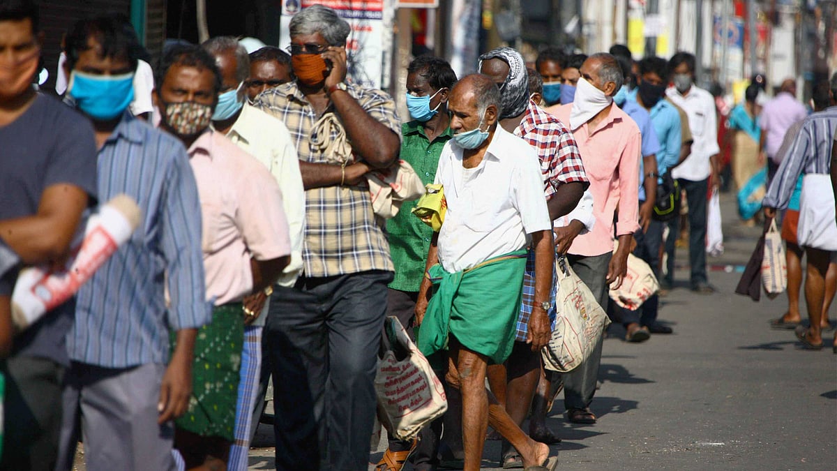 People stand in a queue to buy groceries and vegetables, during the lockdown, in Coimbatore, Thursday.