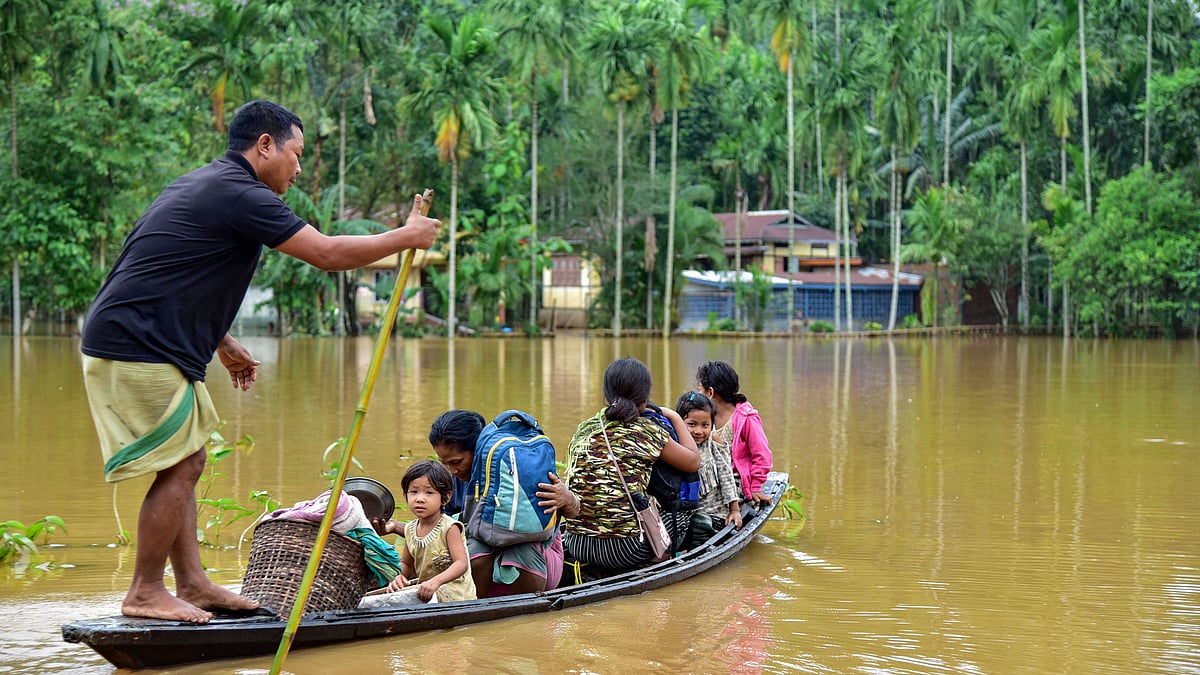 Villagers use a country boat to shift from a flooded locality following heavy rainfall in Goalpara district of Assam, on Monday, 25 May. Heavy rainfall caused flooding in hundreds of villages in Lower Assam.