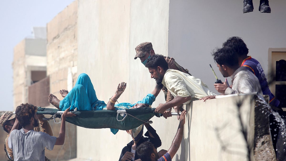 Volunteers carry an injured person at the site of a plane crash in Karachi, Pakistan, on 22 May. 