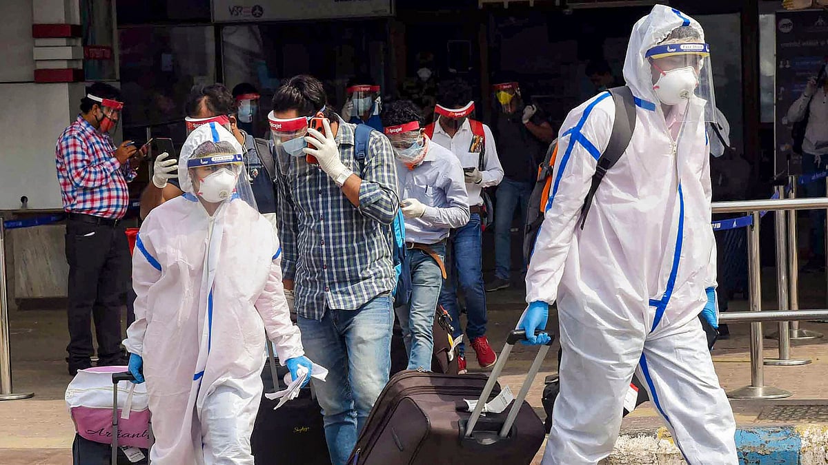 Passengers wearing PPE kits check-out from an airport during the ongoing COVID-19 lockdown.