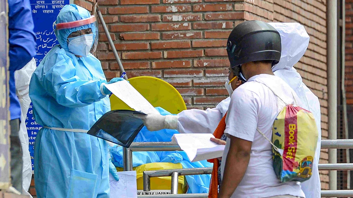 A medic checks the medical documents of a patient at a government hospital during the lockdown in New Delhi on 11 May. Image used for representational purposes. 
