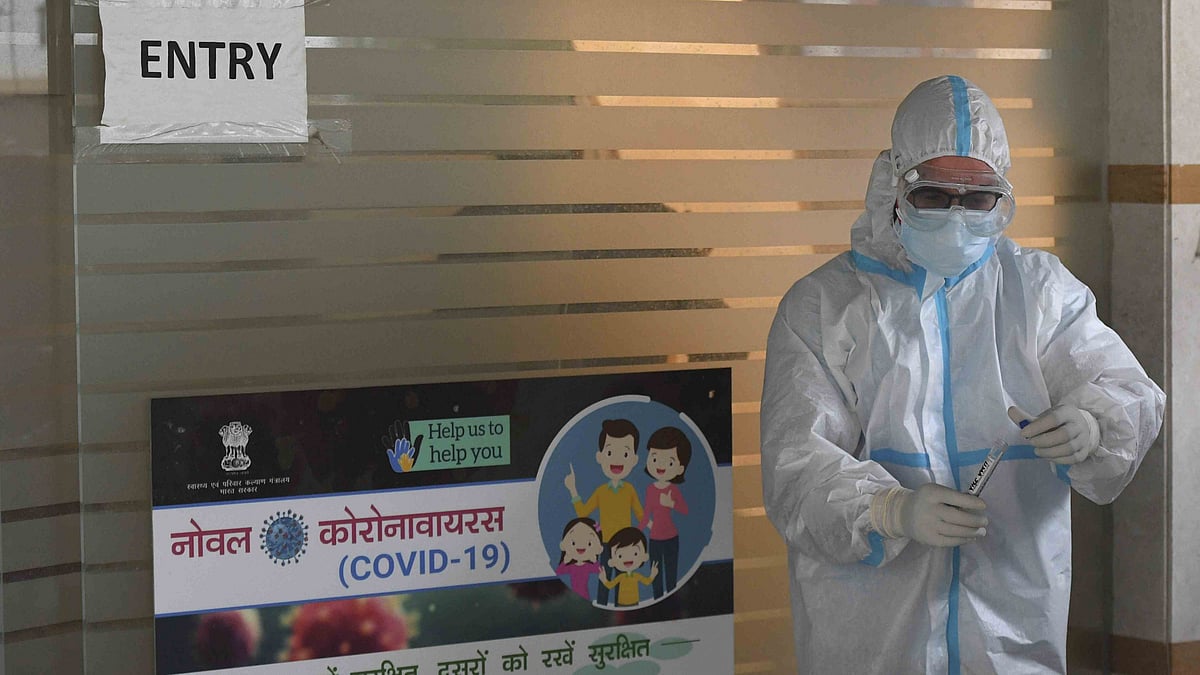 A medic collects samples of people for COVID-19 testing in New Delhi on 13 June.