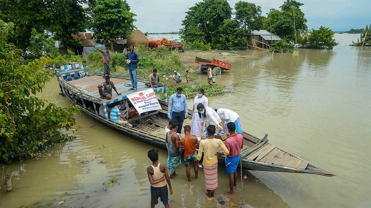 A team of medics provide medicines to the flood-affected people in Morigaon district of Assam.