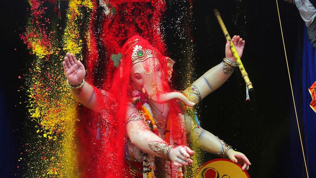 Turmeric and vermilion powder are poured on a giant idol of Lord Ganesha as it is taken for immersion on the tenth day of the ten-day long Ganesh Chaturthi festival in Mumbai, on Thursday, 12 September 2019. 