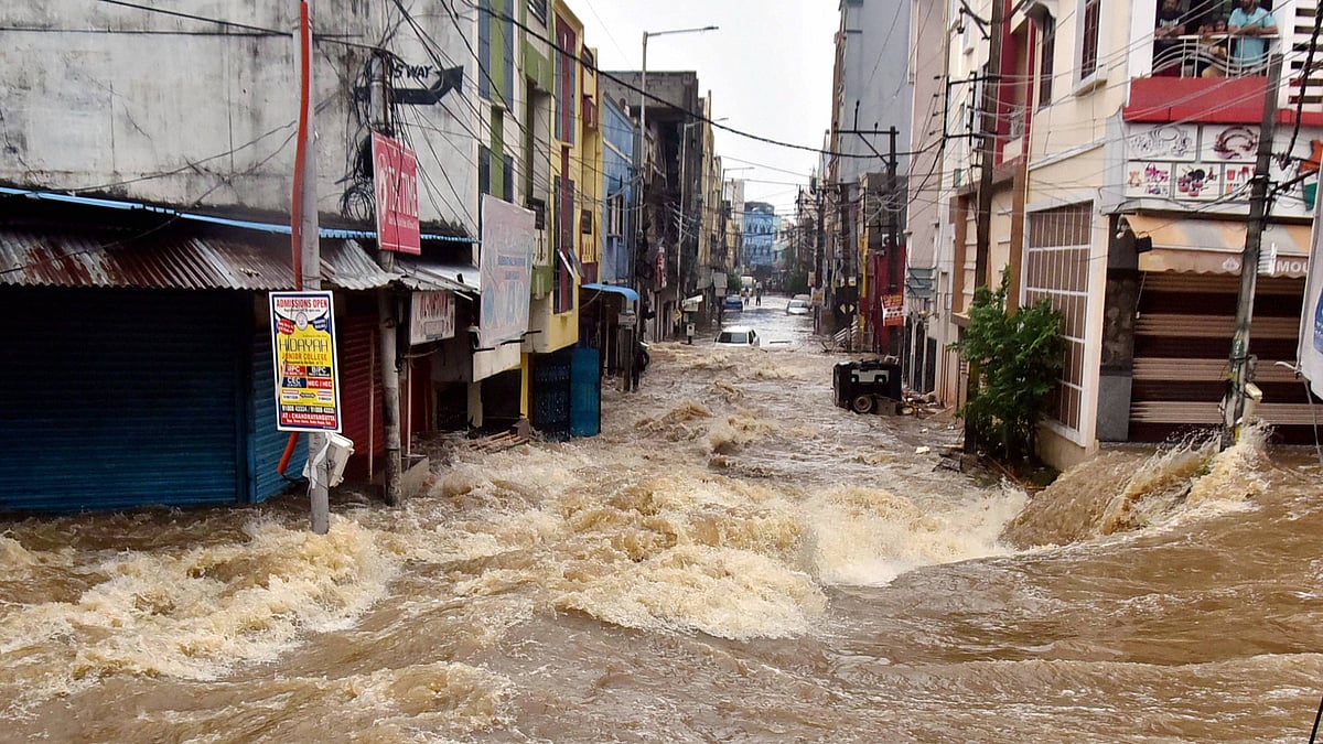 Floodwater gushes through a street following heavy rains, at Falaknuma, in Hyderabad, Wednesday, 14 October 2020.