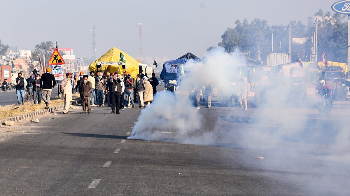 Tear gas shells fired by the Delhi Police land near protesting farmers to warn them, as they try to cross the border into Delhi during their “Delhi Chalo” protest against Kisan Bill, at Singhu border