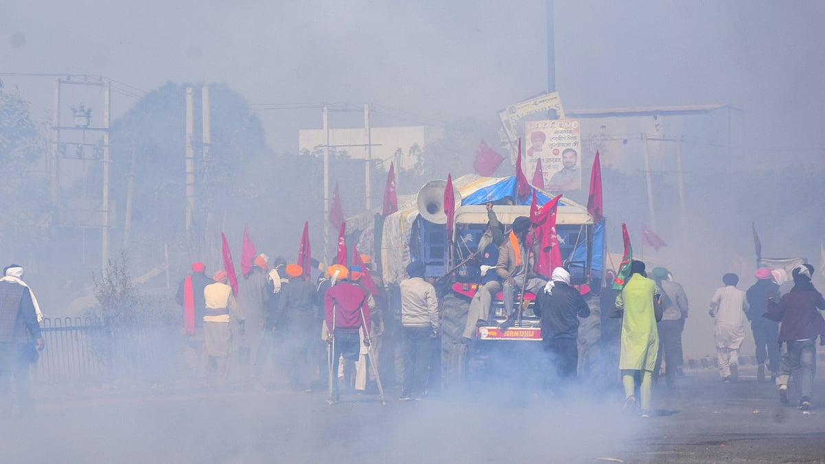 Police personnel use tear gas on farmers to stop them from crossing Singhu Border during the “Delhi Chalo” protest march against the new farm laws.