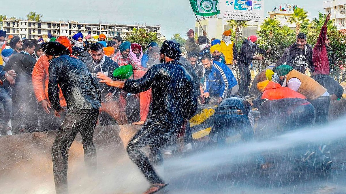 Police use water cannons to disperse farmers during their Kisan Mahapanchayat rally in Kaimla village, in Karnal.