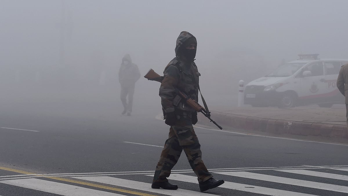 A security personnel walks across a road during the rehearsals for Republic Day Parade amid dense fog at Rajpath, in New Delhi, Saturday, 16 January 2021. 