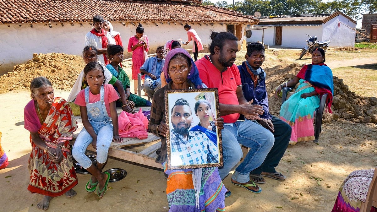 Sushila shows a photograph of her son Manjanu Bakhla, a worker at Tapovan-Vishnugad hydel project who went missing after the glacier burst in Chamoli district, at her house in Mahurangvillage in Lohardaga district, Wednesday, 10 February.