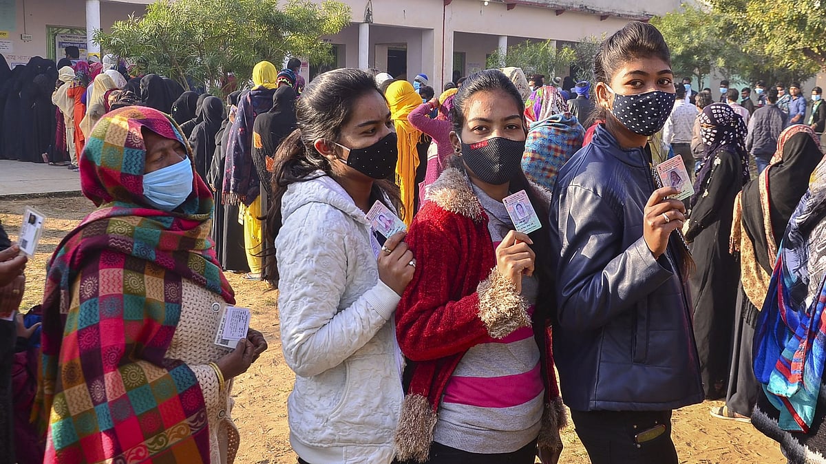 Voters show their identity cards as they wait at a polling station to cast their votes for Rajasthan Municipal Election 2021.