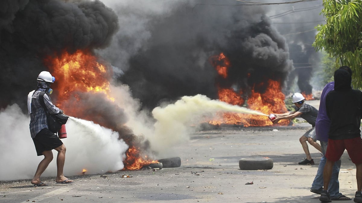 Anti-coup protesters extinguish fires during a protest in Thaketa township Yangon, Myanmar, Saturday, 27 March. Image used for representation.