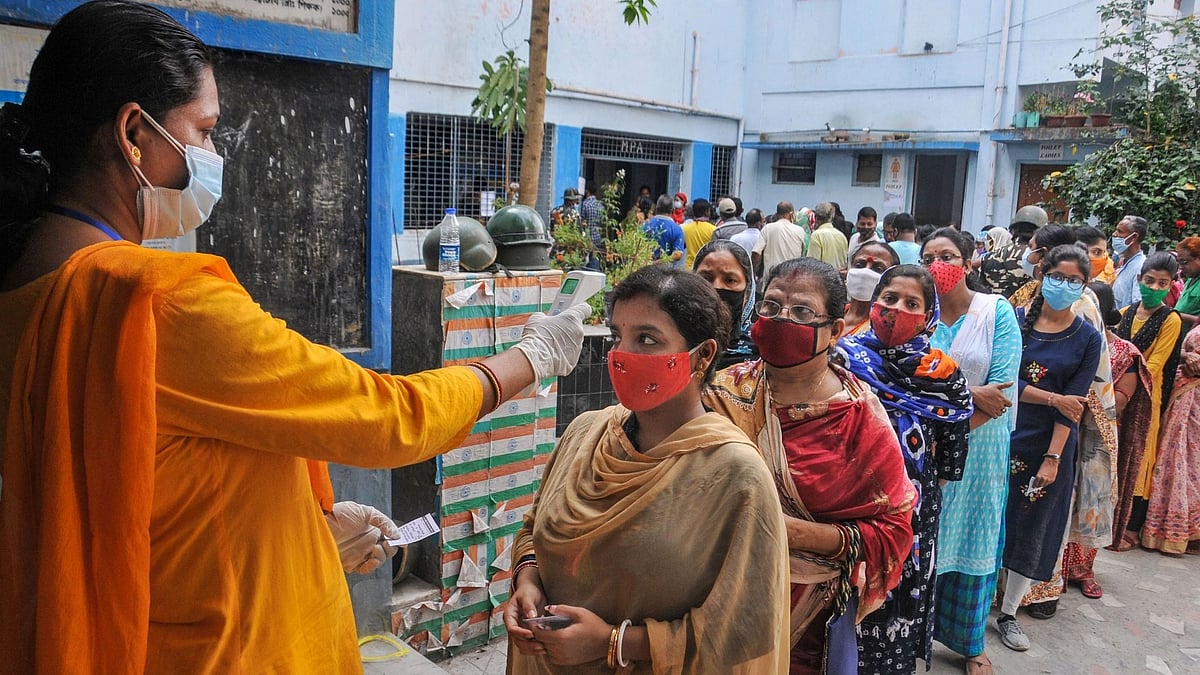People stand in a queue to cast their vote at a polling station during the 6th phase of state Assembly Election at Birati, in North 24 Parganas. 