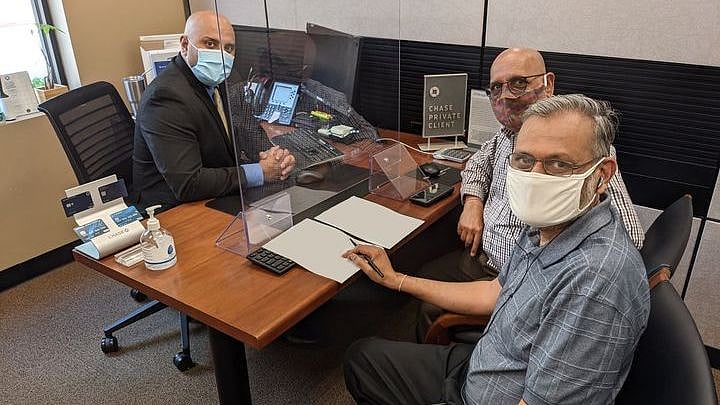 Arun Kankani, President of Sewa International USA, and Yagnesh Patel, Compliance Manager of Sewa International USA, at the bank.