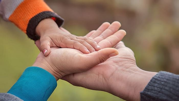 Image of a child’s hand in an adult’s used for representational purposes. 