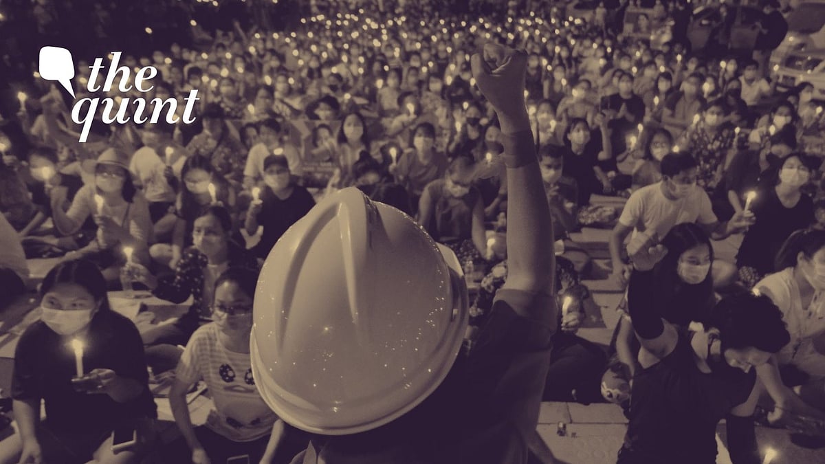 An anti-coup protestor raises his clenched fist in front of a crowd during a candlelight night rally in Yangon, Myanmar, on Sunday, 14 March. Image used for representation purpose.