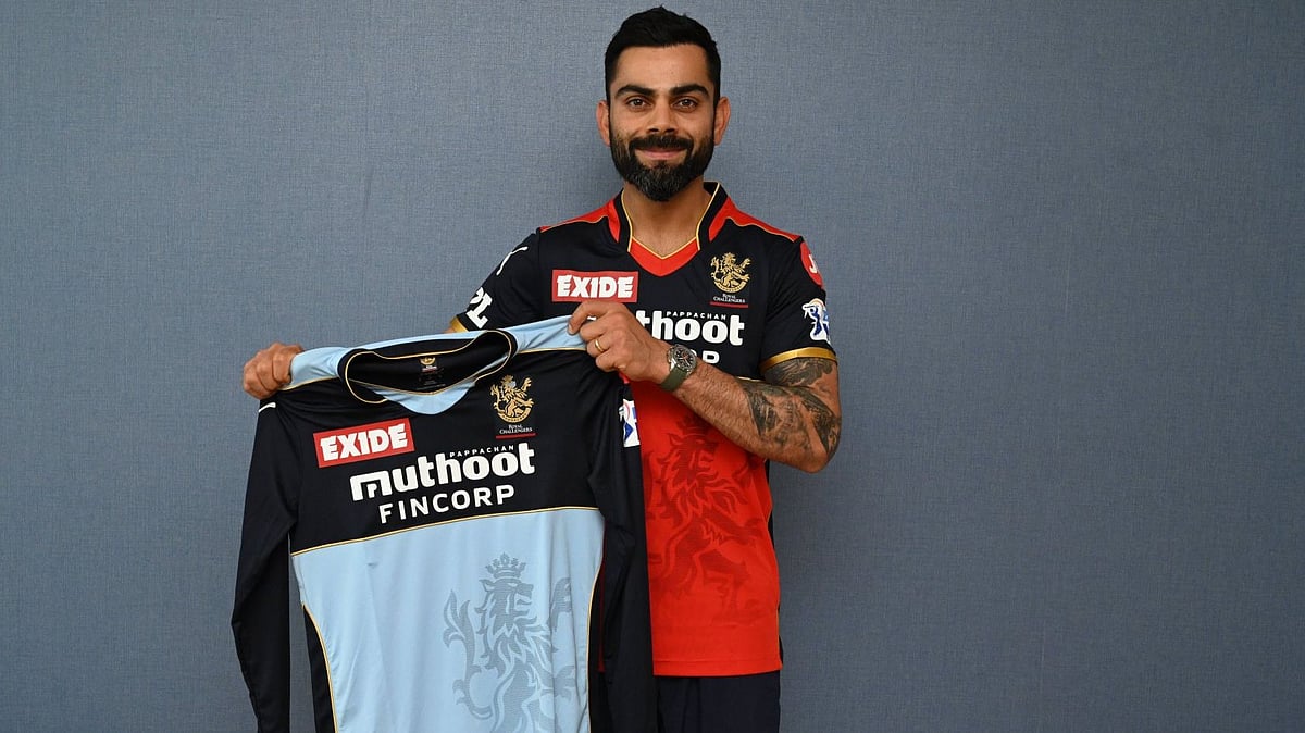 <div class="paragraphs"><p>Virat Kohli poses with the special blue jersey RCB will wear against KKR. </p></div>