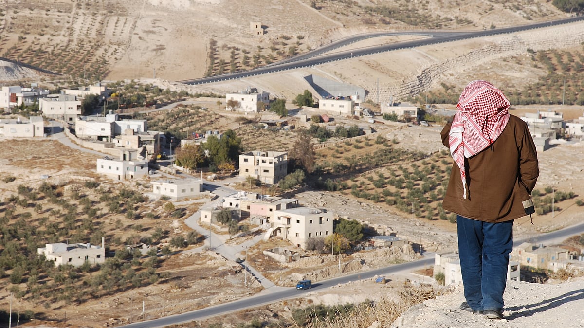 <div class="paragraphs"><p>A Palestinian looks at a village on the outskirts of a town in the West Bank. </p></div>