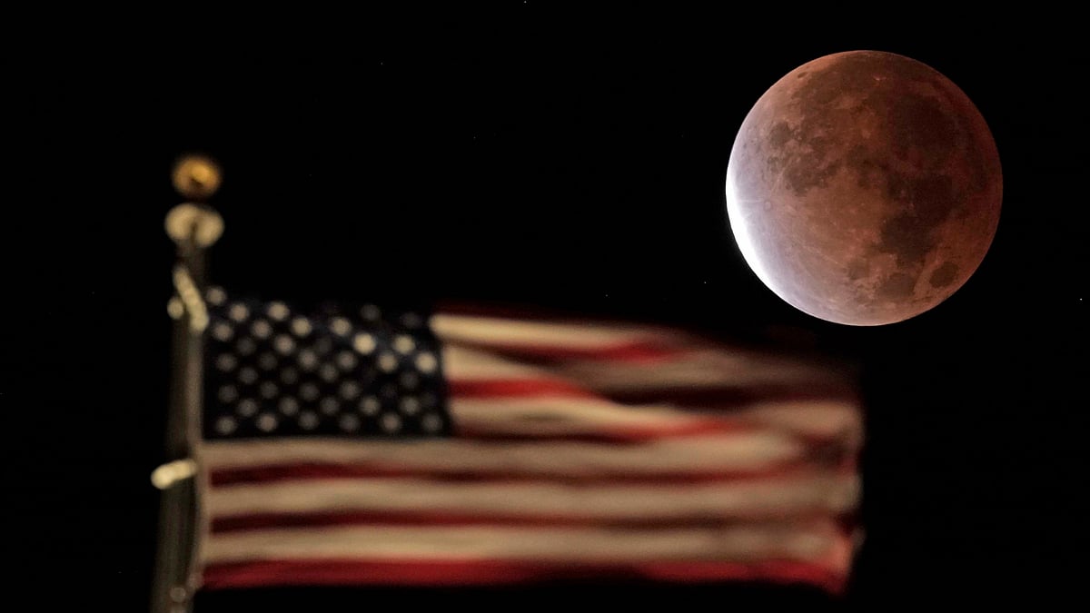 <div class="paragraphs"><p>The earth's shadow covers the full moon during a partial lunar eclipse as it sets beyond the U.S. flag on top of a building, Friday, 19 November, in downtown Kansas City.</p></div>