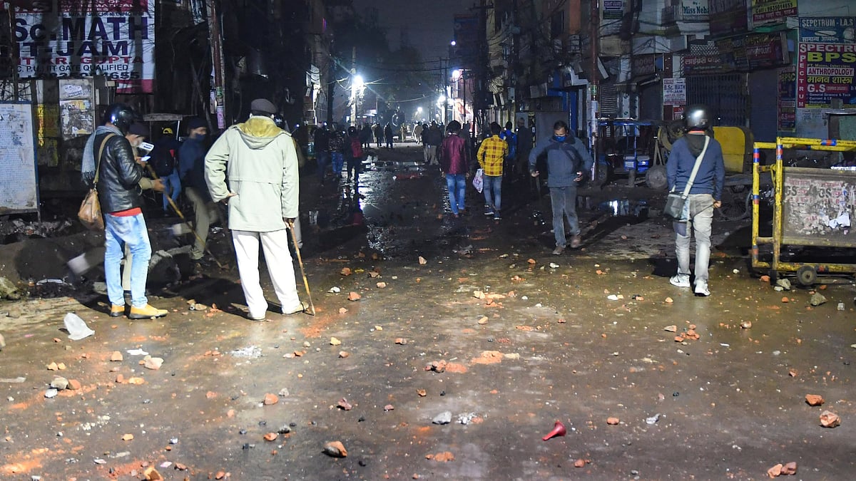 <div class="paragraphs"><p>Police stand on a road littered with brickbats during a protest over alleged erroneous results of Railway Recruitment Boards Non-Technical Popular Categories (RRB NTPC) exam 2021, in Patna, Tuesday, 25 January.<br></p></div>