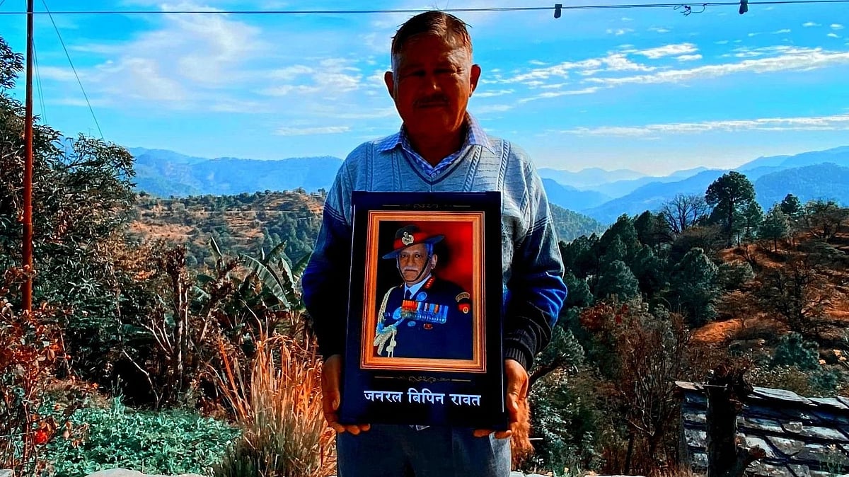 <div class="paragraphs"><p>Bharat Singh Rawat stands with a picture of the late CDS, Gen. Bipin Rawat. </p></div>