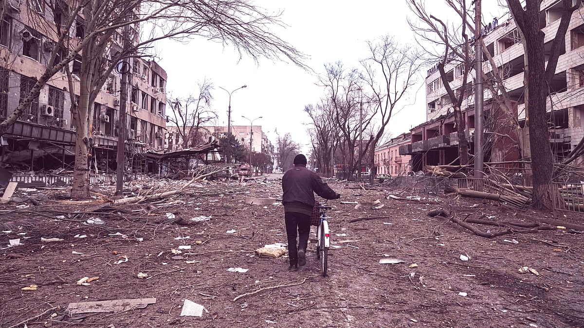 <div class="paragraphs"><p>A man walks with a bicycle in a street damaged by shelling in Mariupol, Ukraine, Thursday, 10 March. Photo for representation. </p></div>