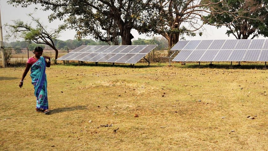 <div class="paragraphs"><p>A woman working in the mustard cake processing unit at Guniya in Jharkhand passes through the solar mini-grid in her village. </p></div>