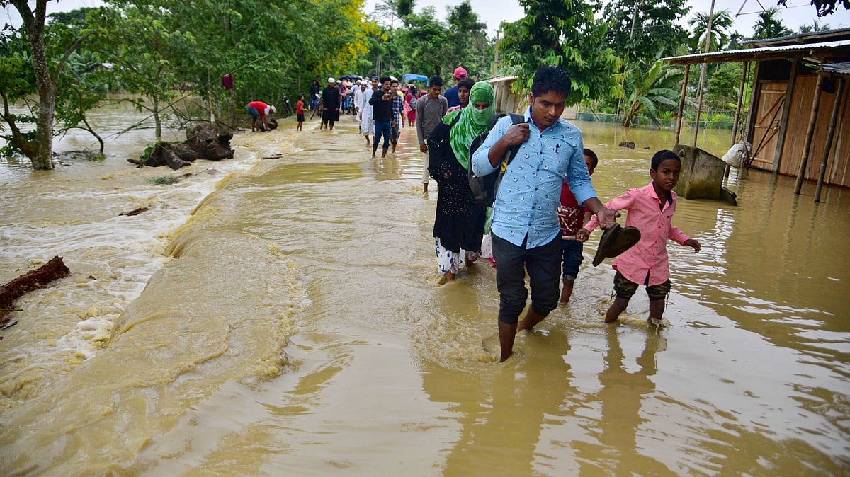 <div class="paragraphs"><p>Villagers wade through a flood-affected area following heavy rains in Hojai district of Assam. </p></div>