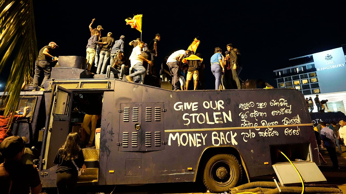 <div class="paragraphs"><p>Protesters stand on a vandalised police water canon truck and shout slogans at the entrance to the president's official residence in Colombo, Sri Lanka, Saturday, 9 July.</p></div>