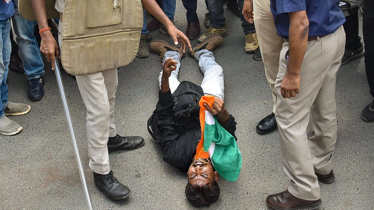 <div class="paragraphs"><p>A candidate lies on the road after he was hit by Additional District Magistrate (Law & Order) KK Singh with a baton during a protest in Patna, on 22 August 2022.</p></div>