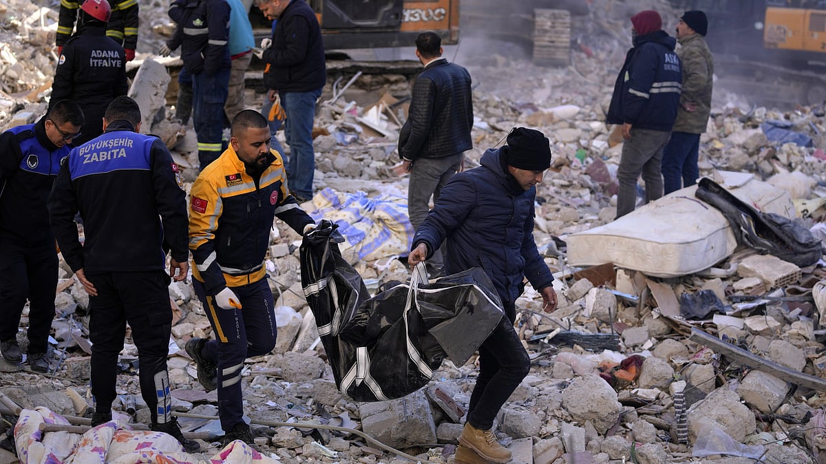 <div class="paragraphs"><p>Two men carry a body from a destroyed building in Adana, southern Turkey, on Tuesday, 7 February. </p></div>